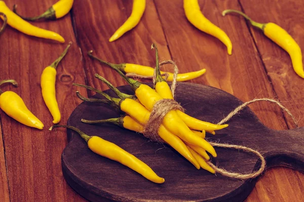 Peperoncini Gialli Legati Con Filo Adagiati Una Scura Tavola Legno — Foto Stock