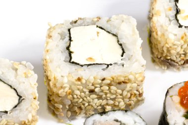 Beyaz arka planda suşi rulosunu kapatmak, restoranda suşi yemek, seçici odaklanma..