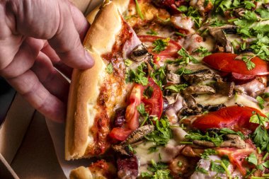 Abur cubur, kalori. Taze domatesli ev yapımı mantarlı pizza. Pizza zamanı. Erkek eli pizza dilimlerini ya da kutuları alıyor..