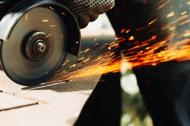 Açı öğütücü makine ve kıvılcımlarla metal levha öğütülmesi. Kapat.,