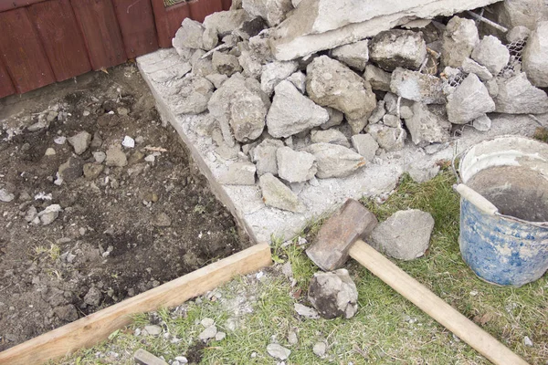 A huge sledgehammer breaks cement into stones — Stock Photo, Image