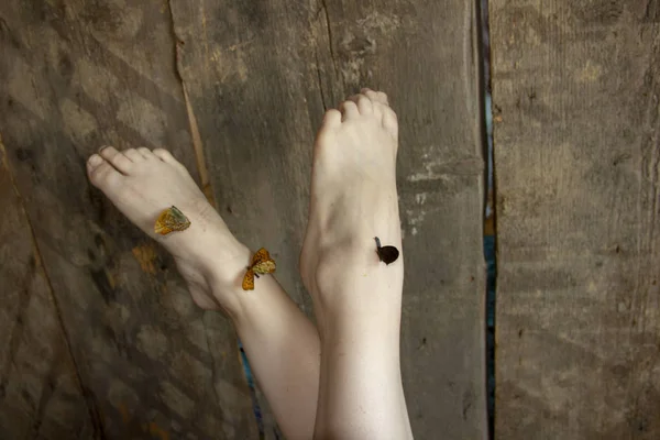 Vackra ben lyfts upp. Fjärilar sitter på fötterna. Lätthet av ben. — Stockfoto