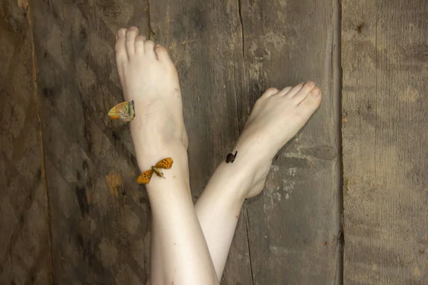 Vackra ben lyfts upp. Fjärilar sitter på fötterna. Lätthet av ben. — Stockfoto