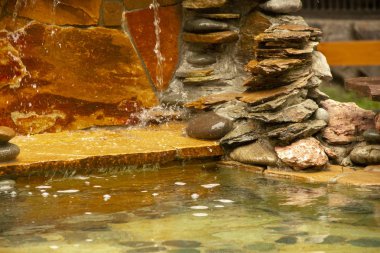 yapay şelale. bahçe ve park dekorasyonu. Su düşüyor. Taşlarda su atıyor.