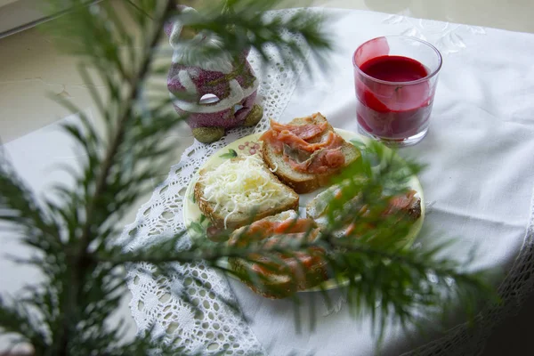 Sandwiches with cheese and fish are visible through the spruce branch. home decor for the new year — Stock Photo, Image