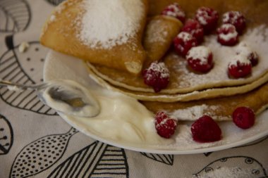 ahududu ile bir tabakta krep ve pudra şekeri serpilir. Tatil - Shrovetide. yuvarlak tedavi