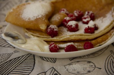 ahududu ile bir tabakta krep ve pudra şekeri serpilir. Tatil - Shrovetide. yuvarlak tedavi