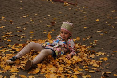 Sarı yaprakların üzerinde yatan kız. sonbahar eğlencesi