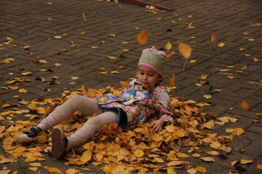 Sarı yaprakların üzerinde yatan kız. sonbahar eğlencesi