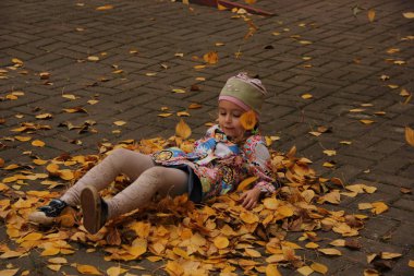 Sarı yaprakların üzerinde yatan kız. sonbahar eğlencesi