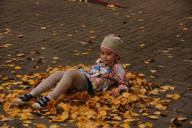 Sarı yaprakların üzerinde yatan kız. sonbahar eğlencesi