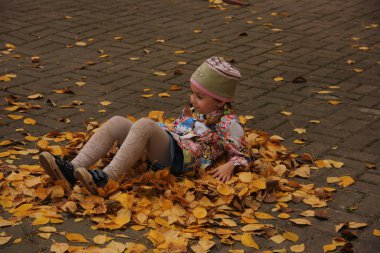 Sarı yaprakların üzerinde yatan kız. sonbahar eğlencesi