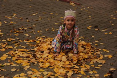 Sarı yaprakların üzerinde yatan kız. sonbahar eğlencesi