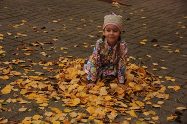 Sarı yaprakların üzerinde yatan kız. sonbahar eğlencesi