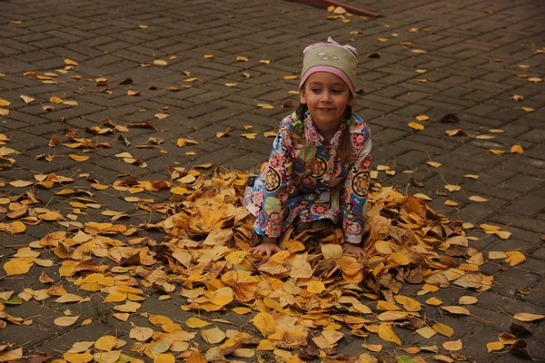 Sarı yaprakların üzerinde yatan kız. sonbahar eğlencesi