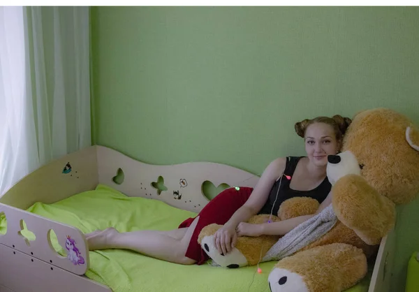 침대에 곰 인형을 두고 있는 소녀 — 스톡 사진