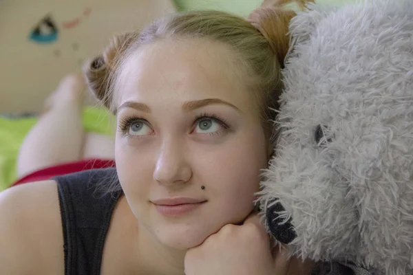 Chica con un oso de peluche en la cama en la habitación —  Fotos de Stock