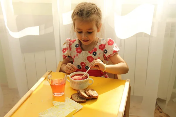 Anaokulu kızı rahat bir restoranda ya da anaokulunda lezzetli yemekler yiyor.
