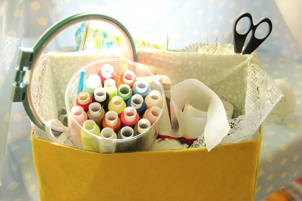 Set for sewing and embroidery in a yellow box on a blue background. scissors and thread in a box — Stock Photo, Image