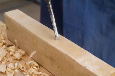 Gri adam ahşap üzerinde çan çalar. Marangozluk işi. 60 yaşında hobi