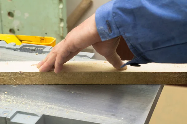 An elderly carpenter handles the bar on the machine. mens work with tools. — Stock Photo, Image