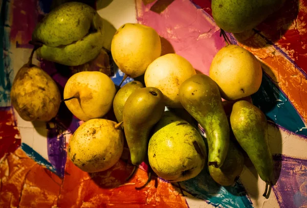Νεκρή ζωή με πράσινα και κίτρινα φρούτα. όμορφα φρέσκα φρούτα στο σκοτάδι. μυστηριώδη πράσινα φρούτα σε μαύρο φόντο — Φωτογραφία Αρχείου