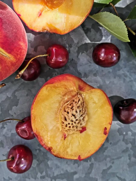 Vista incrível de pêssegos e cerejas na mesa. Frutos brilhantes e suculentos - pêssegos e cerejas — Fotografia de Stock