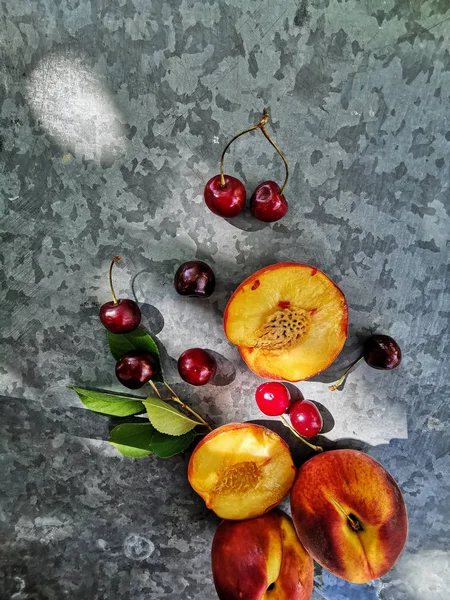 Vista incrível de pêssegos e cerejas na mesa. Frutos brilhantes e suculentos - pêssegos e cerejas — Fotografia de Stock