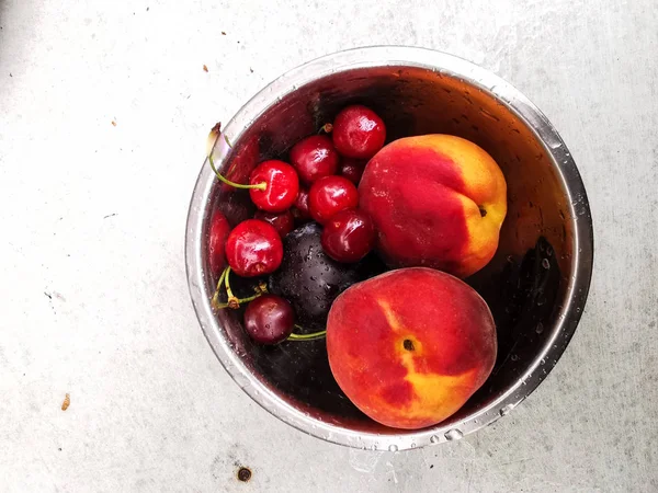 Frutas e frutos frescos maduros do verão, pêssegos, damascos, cereja e morango em um prato redondo — Fotografia de Stock