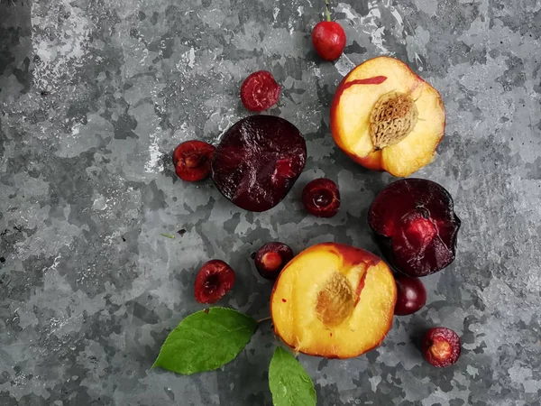 Frutas e frutos frescos maduros do verão, pêssegos, damascos, cereja e ameixa em um prato redondo na mesa — Fotografia de Stock