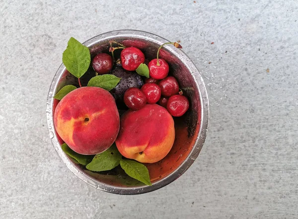 Frutas e frutos frescos maduros do verão, pêssegos, damascos, cereja e morango em um prato redondo — Fotografia de Stock