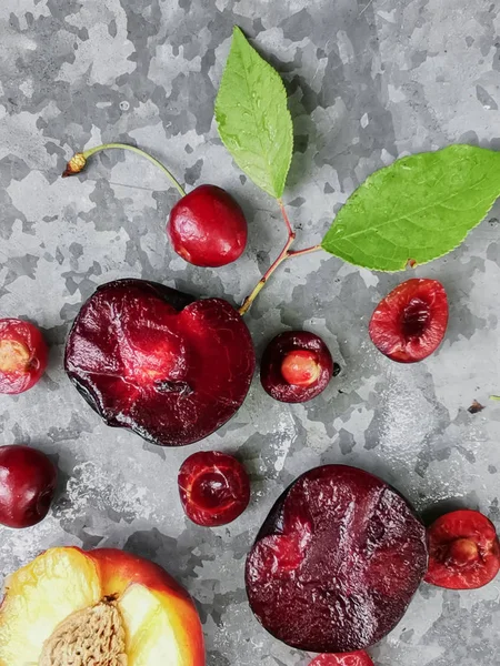 Frutas e frutos frescos maduros do verão, pêssegos, damascos, cereja e ameixa em um prato redondo na mesa — Fotografia de Stock