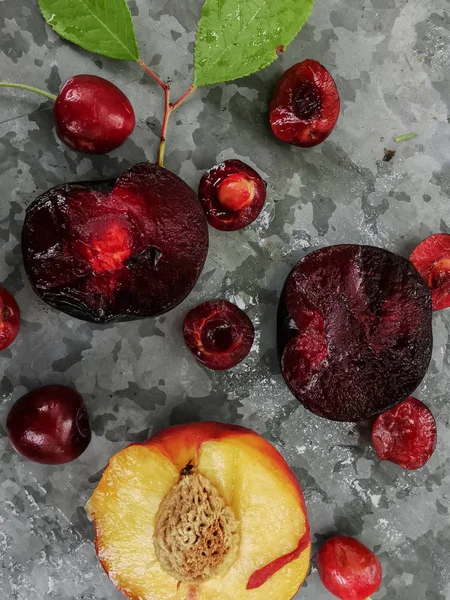 Frutas e frutos frescos maduros do verão, pêssegos, damascos, cereja e ameixa em um prato redondo na mesa — Fotografia de Stock