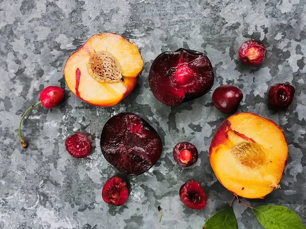 Bayas y frutas frescas maduras de verano, melocotones, albaricoques, cerezas y ciruelas en un plato redondo sobre la mesa —  Fotos de Stock