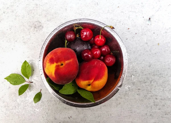 Frutas e frutos frescos maduros do verão, pêssegos, damascos, cereja e morango em um prato redondo — Fotografia de Stock