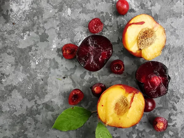 Frutas e frutos frescos maduros do verão, pêssegos, damascos, cereja e ameixa em um prato redondo na mesa — Fotografia de Stock