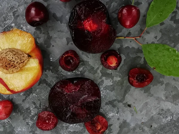 Bayas y frutas frescas maduras de verano, melocotones, albaricoques, cerezas y ciruelas en un plato redondo sobre la mesa —  Fotos de Stock