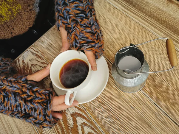 Güzel kadın elleri sıcak kahve beyaz bir fincan tutan. Sıcak kahve bir Fincan tutan bir Cozy sıcak örme kazak bir kız