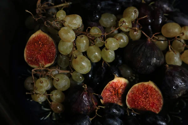 Frutas de otoño recién recogidas. Uvas e higos blancos y negros sobre mesa de madera oscura — Foto de Stock