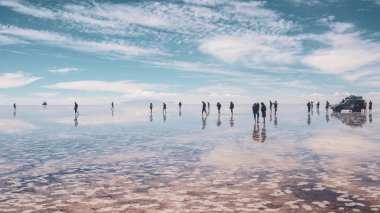 Salar de Uyuni' deki insanlar silueti ve yansımaları, Bolivya