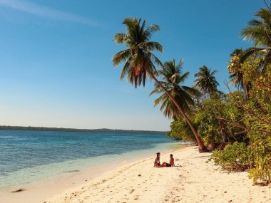 Filipinler Balabac Palawan Onok Adası'nda palmiye ağaçları ile beyaz kumlu plajda rahatlatıcı Lovely çift