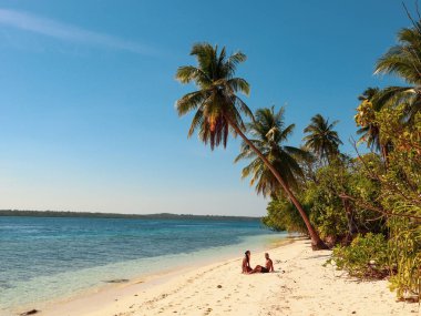 Filipinler Balabac Palawan Onok Adası'nda palmiye ağaçları ile beyaz kumlu plajda rahatlatıcı Lovely çift