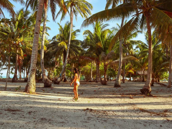 woman walking around into the palm tree jungle in Onok island in Balabac in Philippines