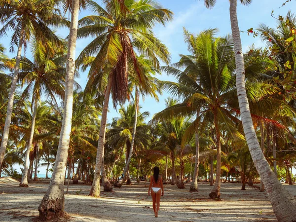 woman walking around into the palm tree jungle in Onok island in Balabac in Philippines