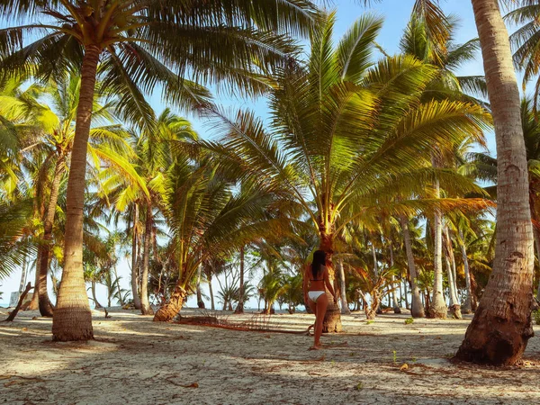 woman walking around into the palm tree jungle in Onok island in Balabac in Philippines