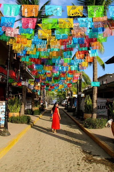 Meksika'da Sayulita sokakta palmiye ağaçları ile renkli bayraklar