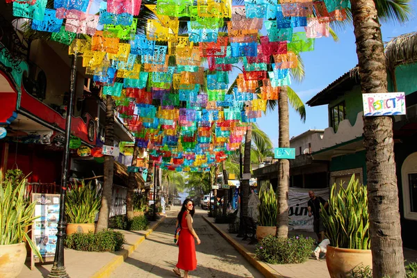 Meksika'da Sayulita sokakta palmiye ağaçları ile renkli bayraklar