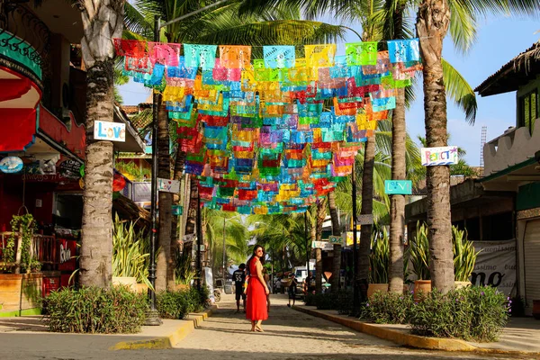 Meksika'da Sayulita sokakta palmiye ağaçları ile renkli bayraklar