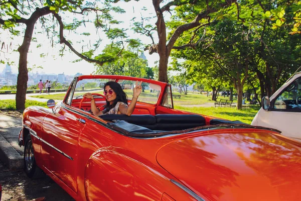 Havana, Küba'da eski turuncu araba kullanan kız