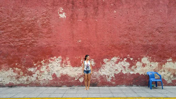 street of Merida with red wall in Yucatan in Mexico